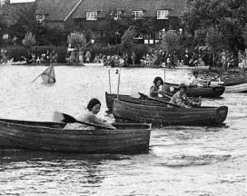 People rowing boats in a river race.