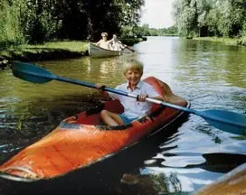 Person kayaking on a calm river.